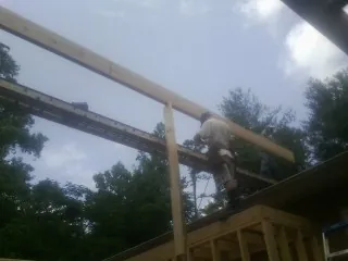 Carpenter setting a ridge beam over a new addition frame — Ice Dam Removal by Roofing Brothers in Middle Grove