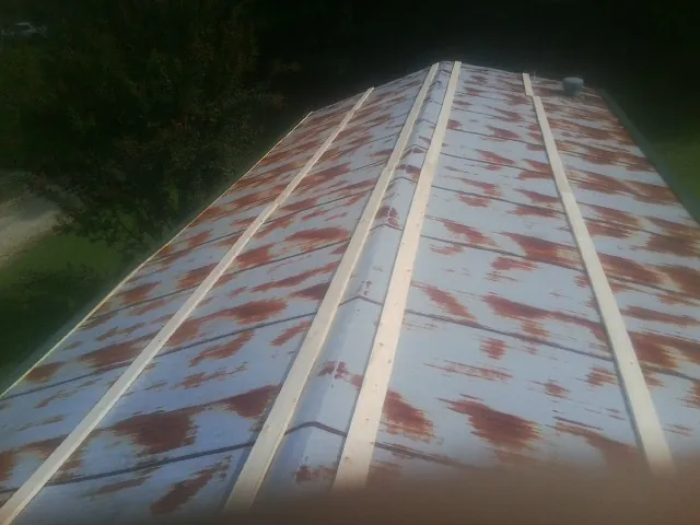 Rusted metal roof panels with new wood purlins before replacement — Storm Damage Roof Repair in Middle Grove by Roofing Brothers