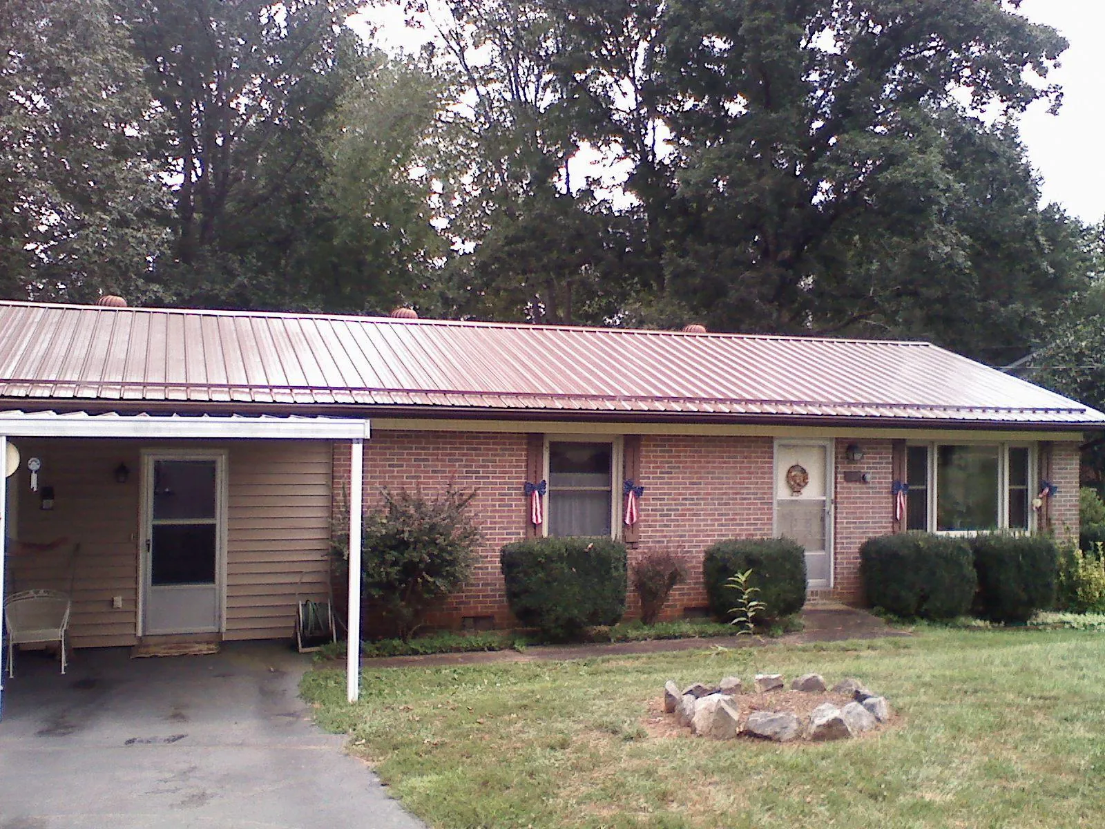 Bronze metal roof and carport on a brick ranch home — Roof Repair work by our crew in Middle Grove